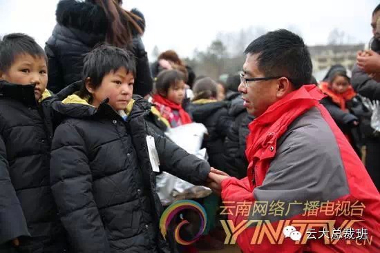 一位男学员把低年级小男孩的手放到自己温暖的大手里，捂热他冰冷的小手